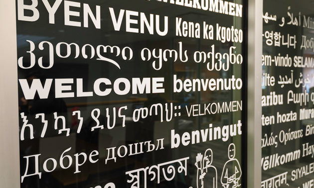 close-up of window of Language Center, covered in greetings in multiple languages.