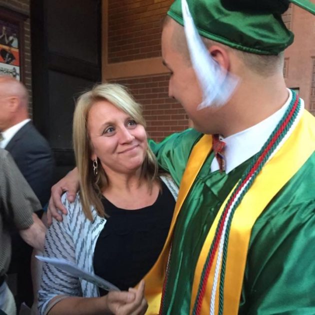 graduate with his arm around his mom