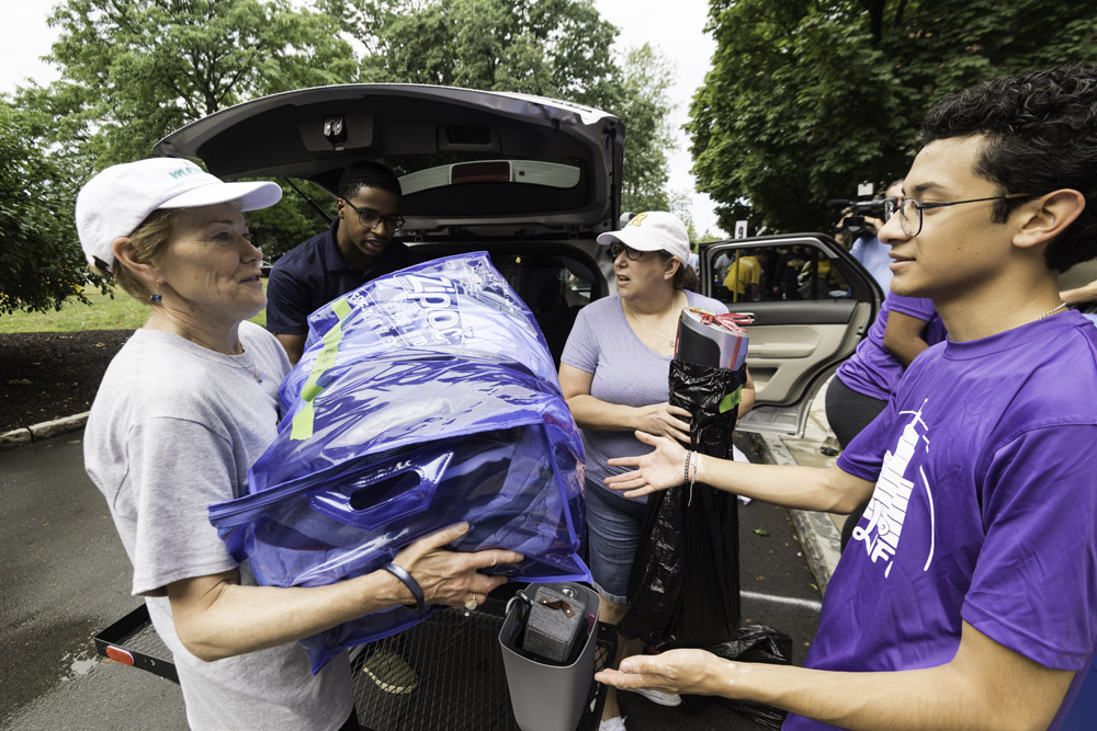 President Mangelsdorf lifts boxes from a student's car.