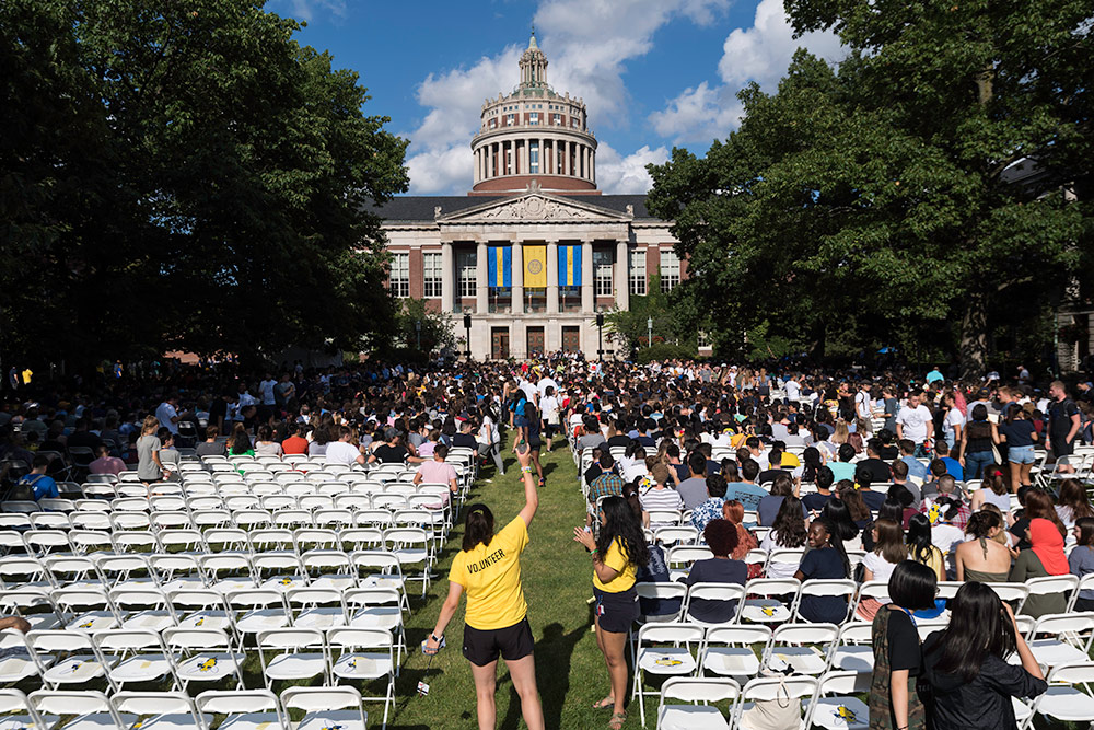 chairs on the quad with the library in the background as students process in