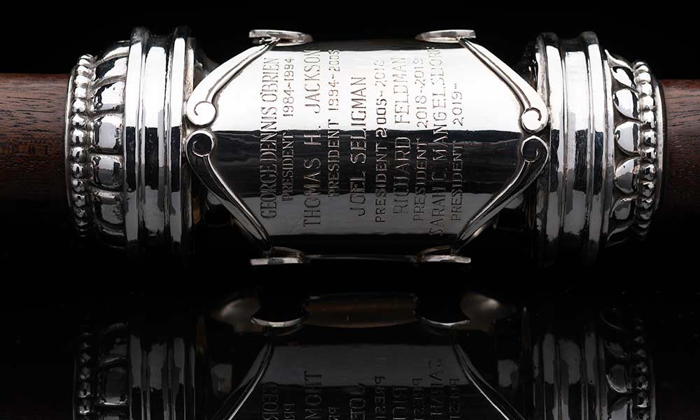 close-up on the engraved silver on the University mace shows the name of the new president, Sarah C. Mangelsdorf along with the date 2019-