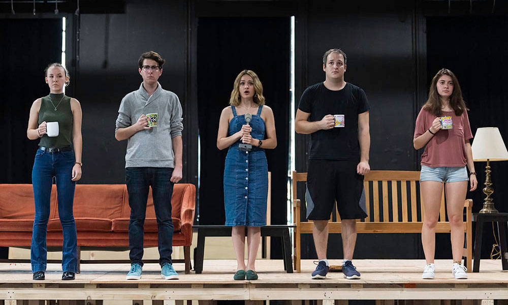 five student actors standing next to each other on stage