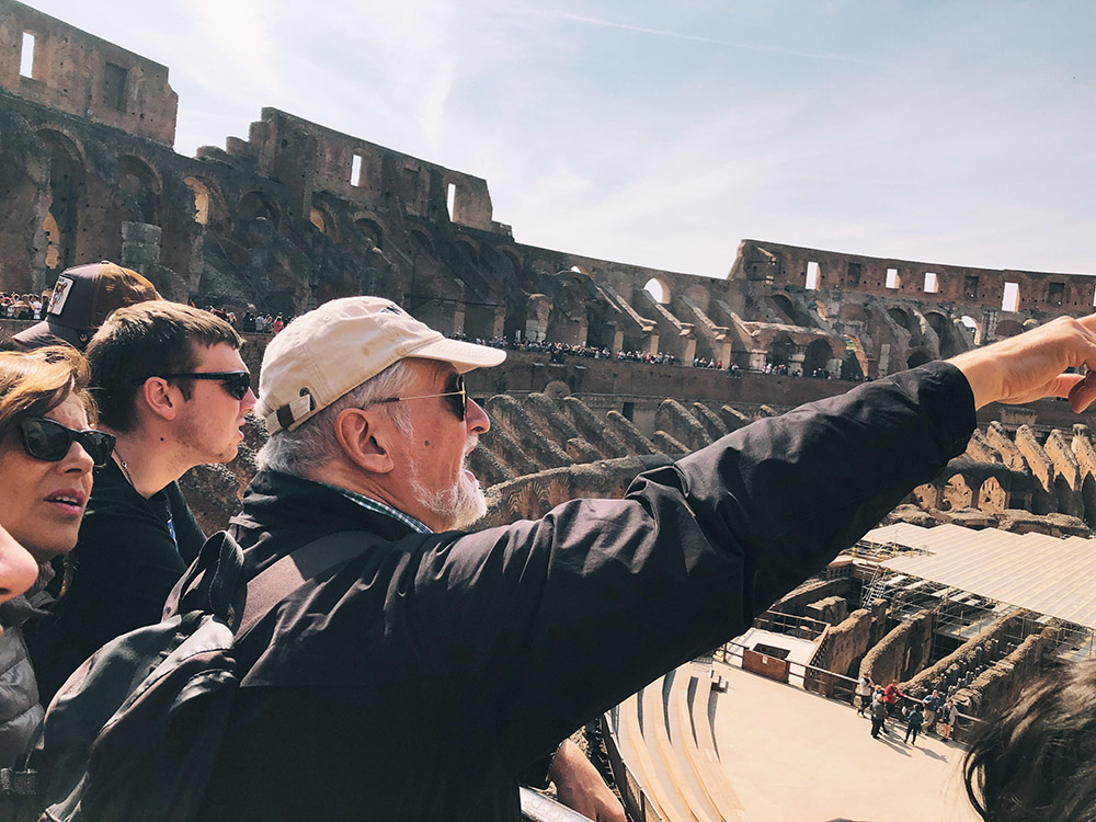 a professor points to something inside the Roman Colosseum