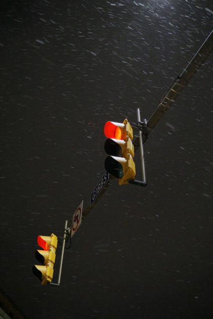 snow flying around two traffic lights