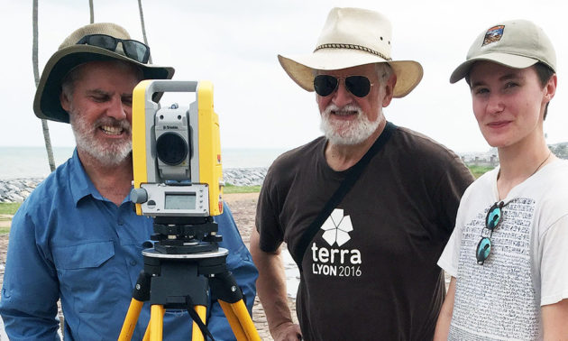 three people pose for a photo with a surveyor tool.