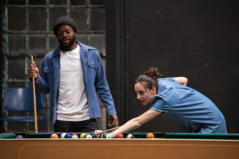 two actors on stage, playing pool.