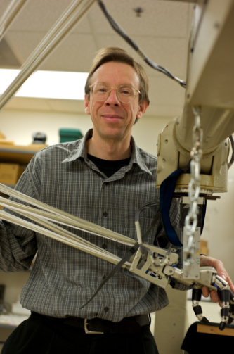 Randal Nelson poses with a robotic arm.