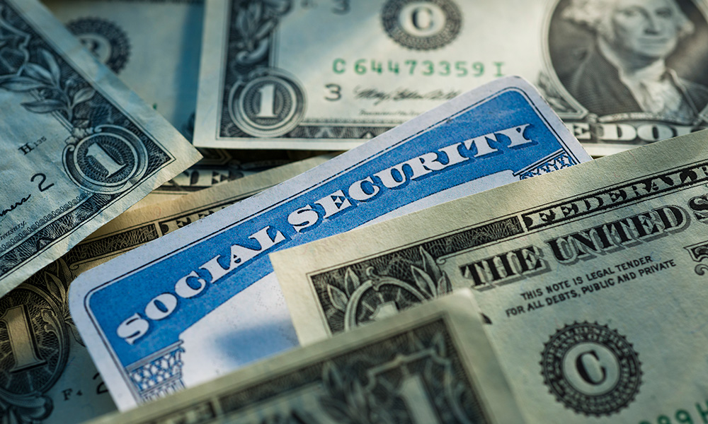 social security card surrounded by dollar bills.