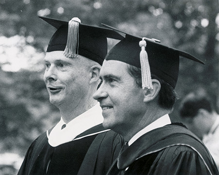 archival photo of Richard Nixon on campus, wearing academic regalia. 