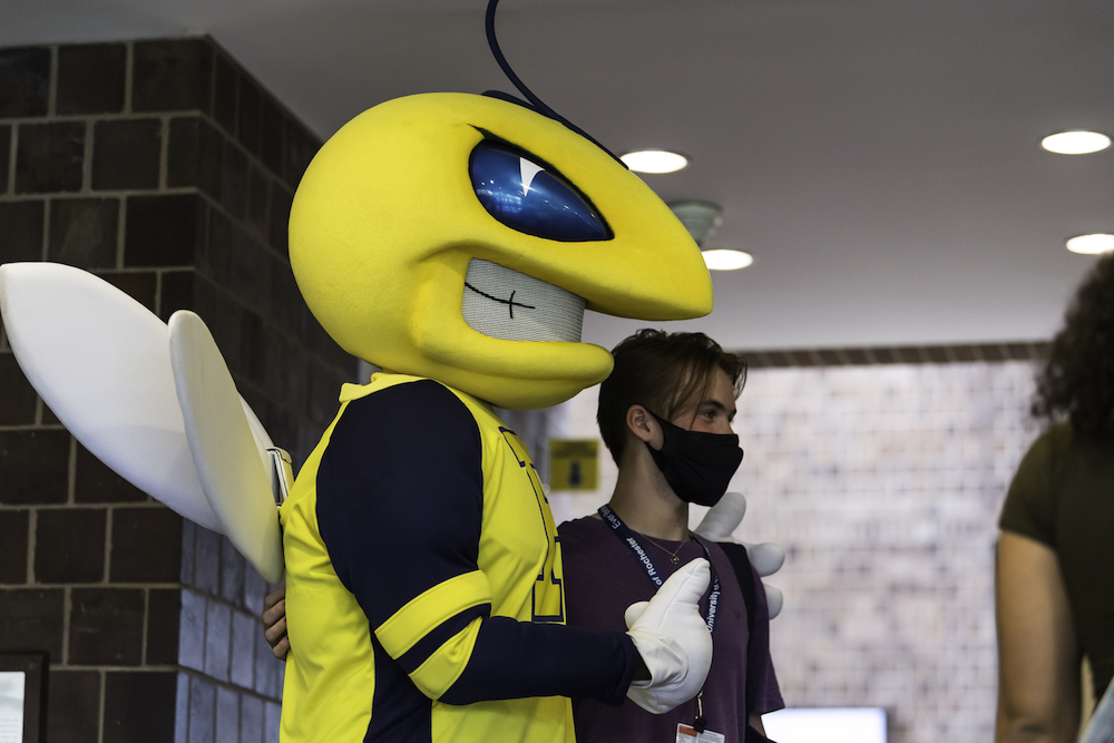 Rocky mascot with his arms around a student