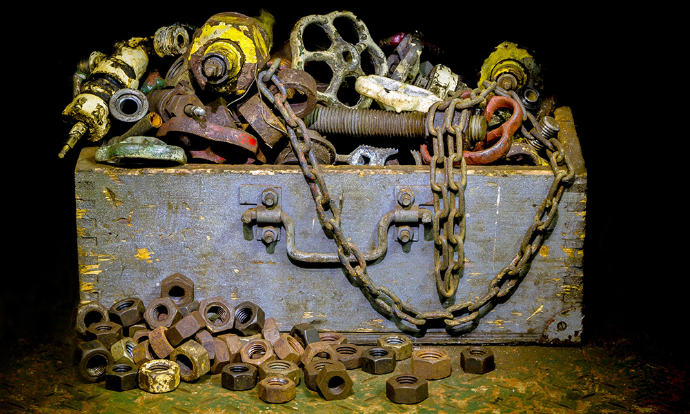 Wooden box overflowing with junk metal.