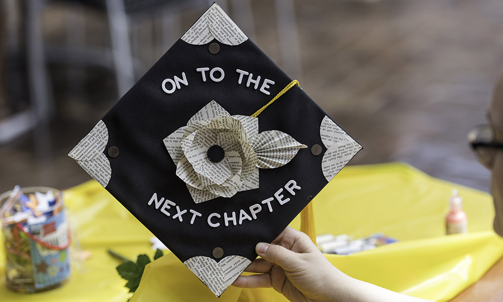 decorated graduation cap that reads On to the Next Chapter to illustrate jobs for recent college graduates.