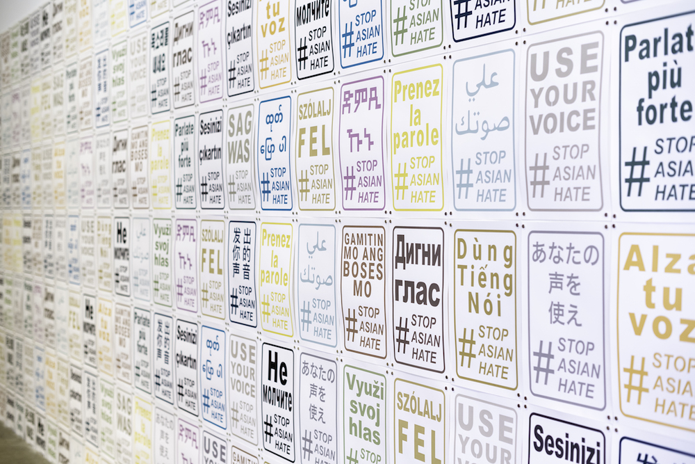several stacked rows of colorful posters in different languages 