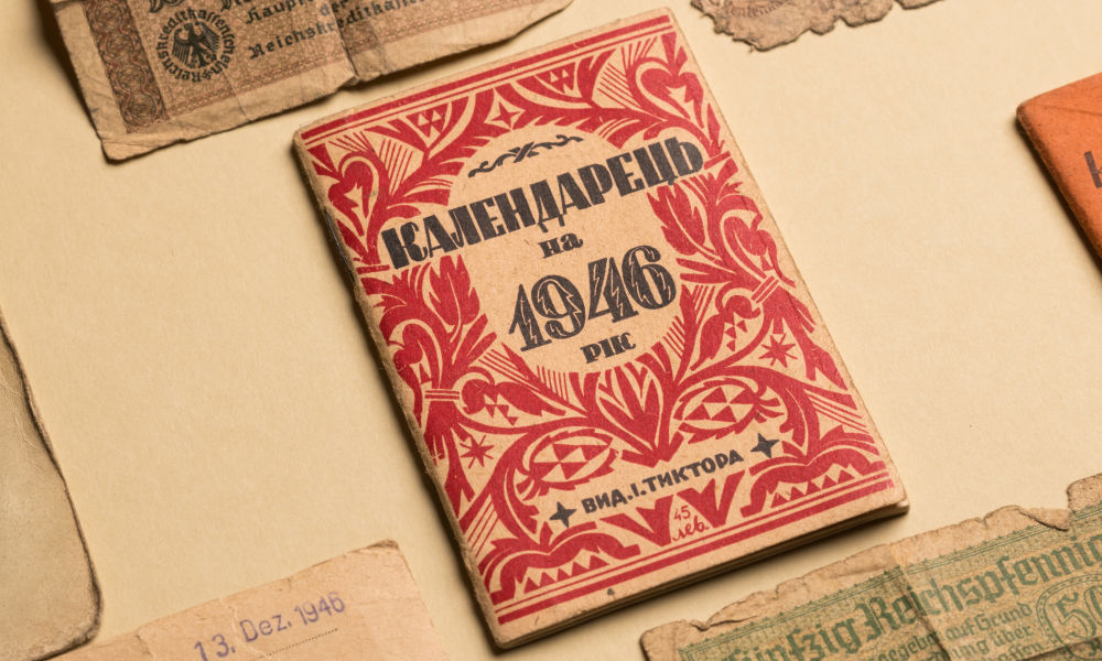 Close-up of items from the Ukrainian Rochester Collection, including a book with a red cover, Cyrillic writing, and the year 1946.