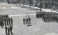 Lines of uniformed Navy trainees stand at attention on Eastman Quadrangle.