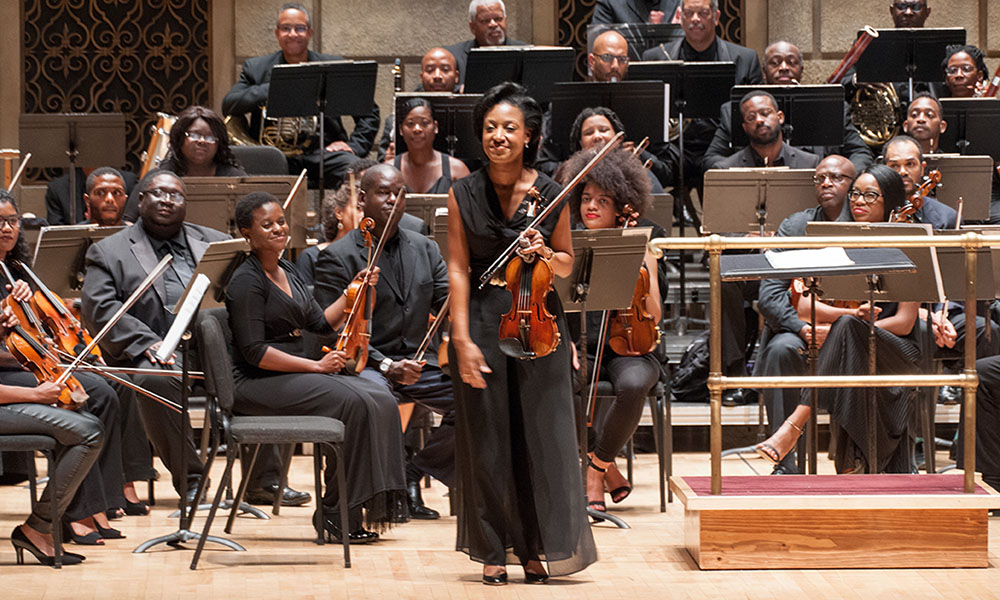 orchestra of African and Africa American musicians on Eastman Theatre stage