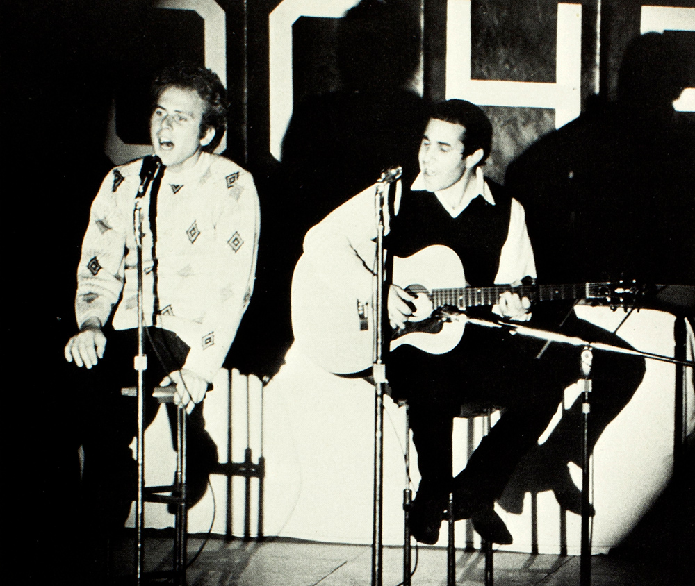 archival concert photo of Paul Simon and Art Garfunkel on stage.