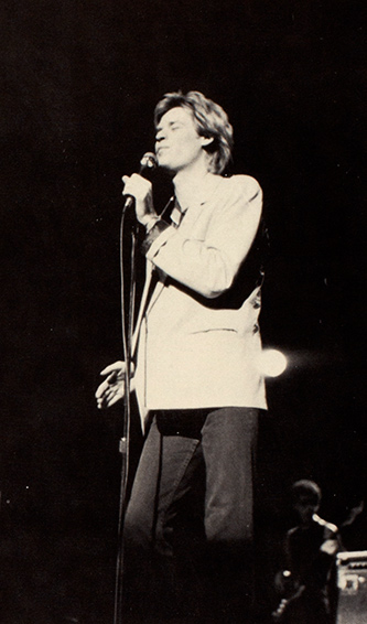 Daryl Hall singing on stage in a black and white yearbook photo.