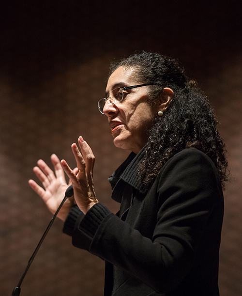 Lani Guinier gestures while speaking from behind the podium.