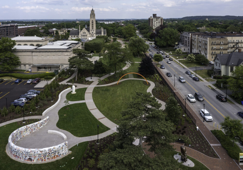 Aerial photo of large sculpture park on the left, banked on the right by a road with cars.