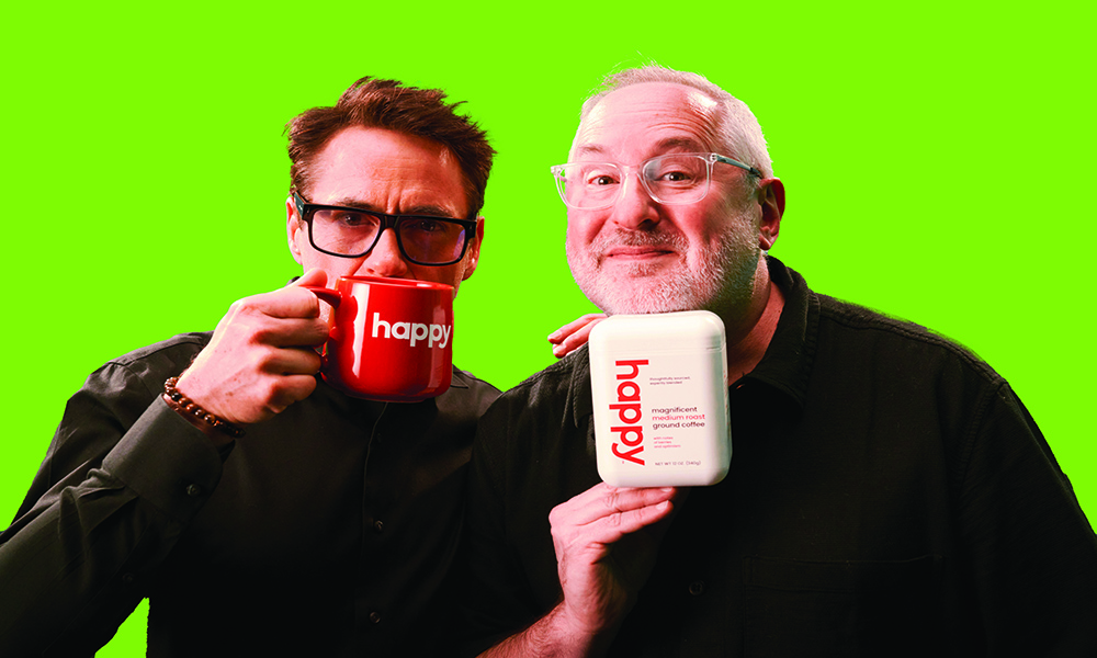 Robert Downey Jr. drinking from a mug that says happy and Craig Dubitsky holding a pod of Happy coffee.