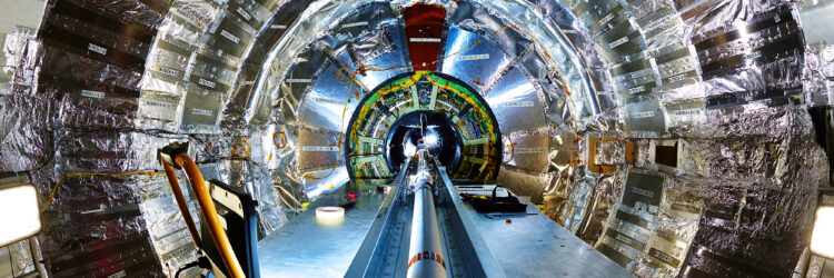 The inside of the CMS detector at CERN, showing a large central beam pipe surrounded by a silver cylinder of detectors.