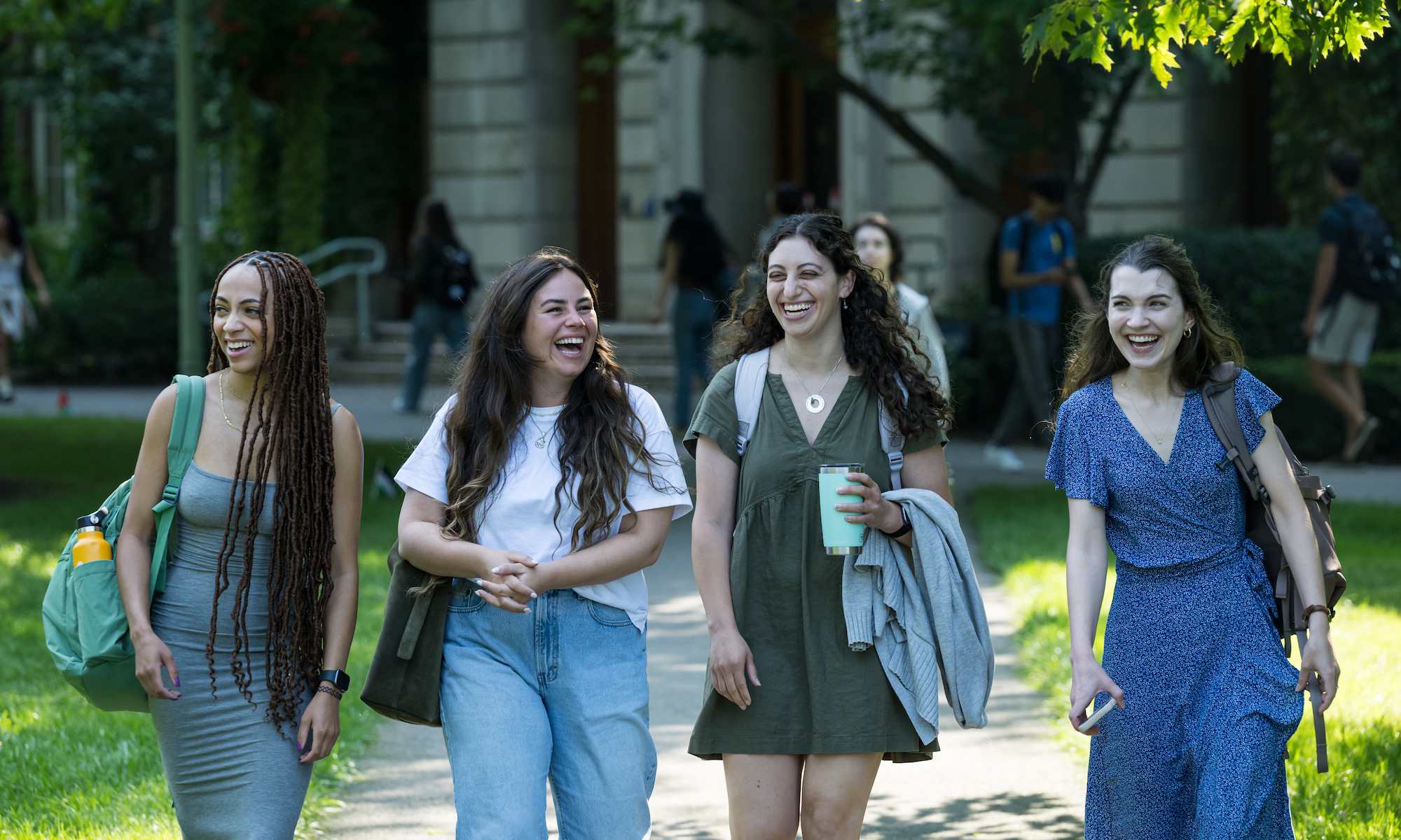 four students walk to class on a fall day