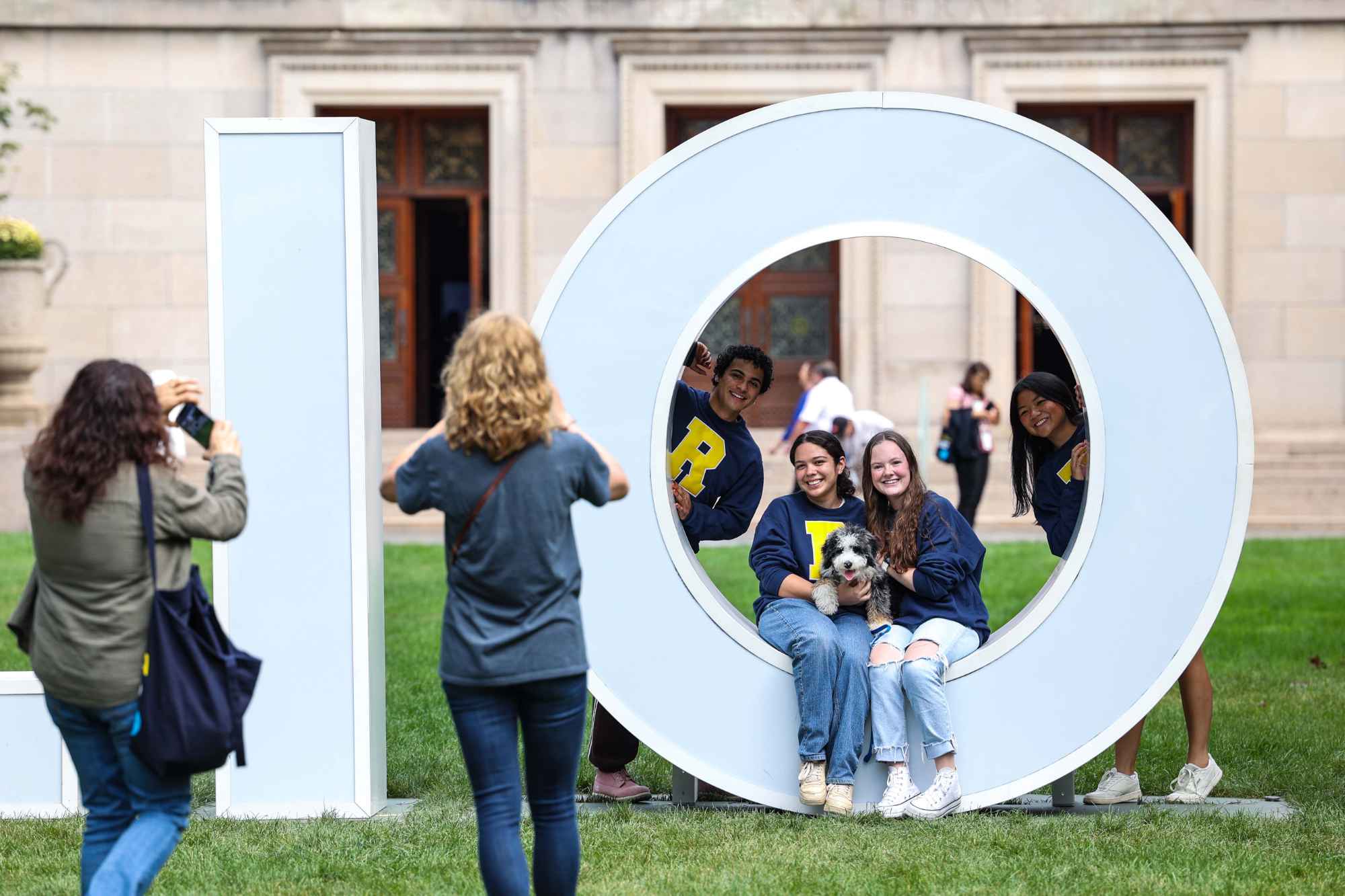 Students pose for a photo in a giant letter 