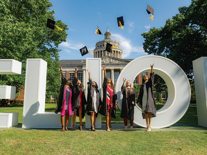 image of 2021 graduates celebrating by meliora letters on eastman quad rochester