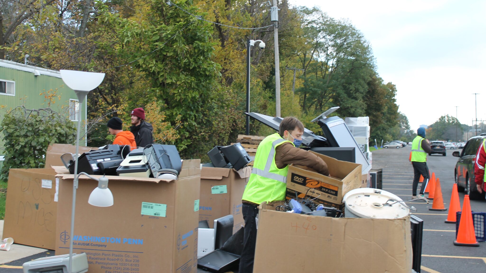 A volunteer sorting through boxes of recycled electronics at the E-Cycle Day event