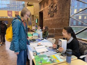 A tabling event where a student is learning about sustainability on the University of Rochester's campus