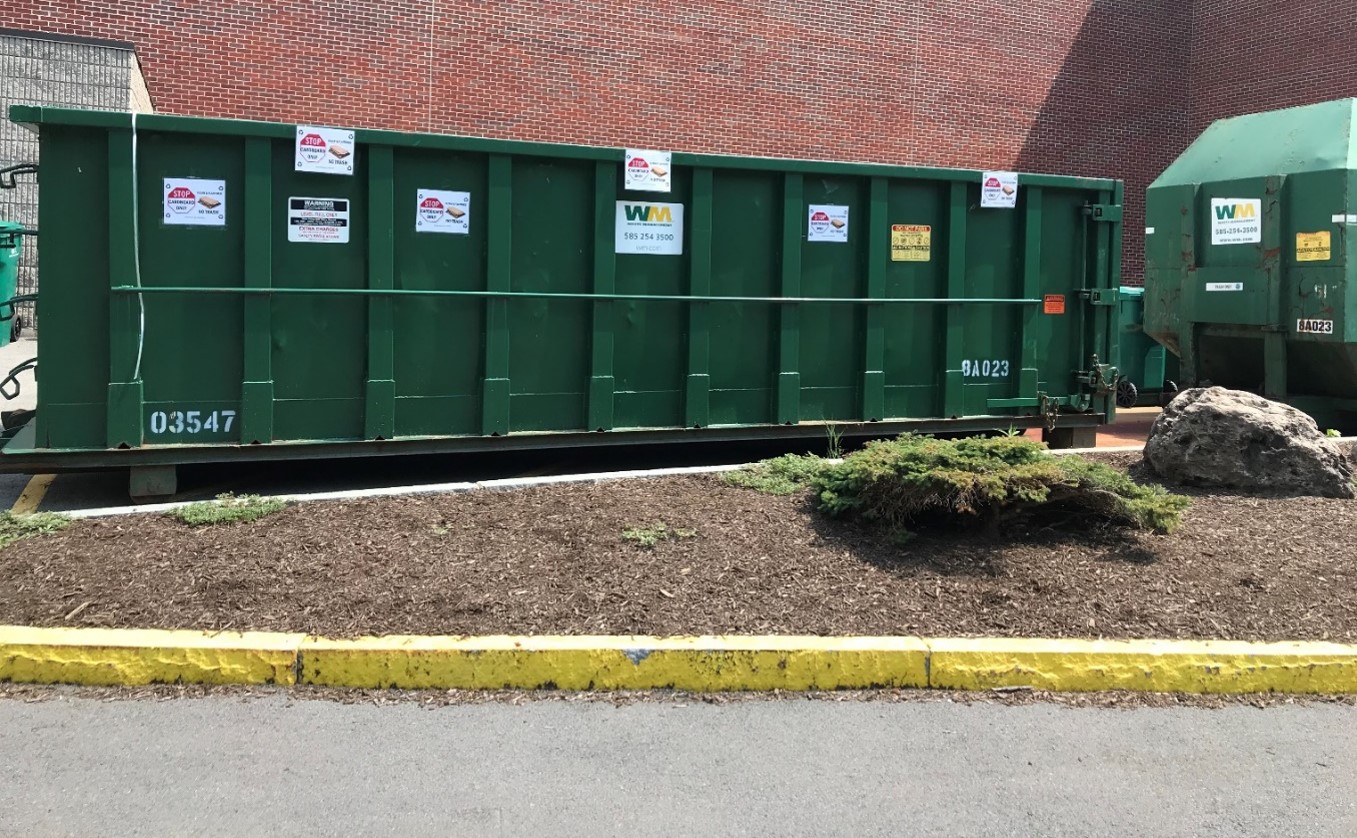 A cardboard recycling container outside of a University building