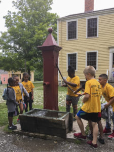 Students playing with an old well at Genesee Country Village and Museum.