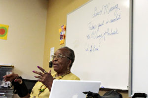 Older woman author speaking in front of a classroom.