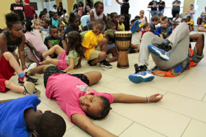 Children laughing and laying on the floor during an activity