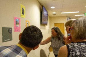 Adults looking at student work on a wall