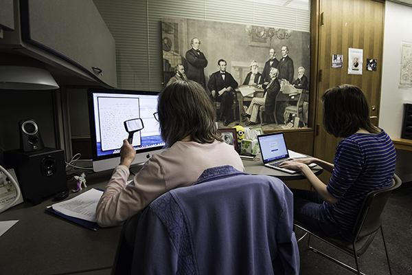 two people working to transcribe scans of historical documents