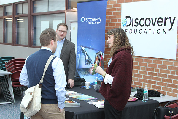 people talking at a conference at a Discovery Education table