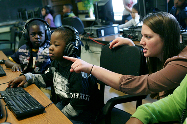 teacher working with students in a computer lab